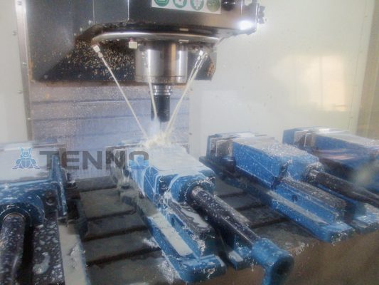 CNC drilling equipment running with a rotating drill and pipes for cutting fluid